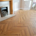 Laminate planks laid in a herringbone pattern.